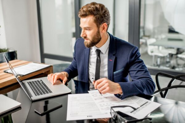 Ein junger Mann mit Anzug beschäftigt sich nach seiner Weiterbildung mit dem Thema Steuerrecht.